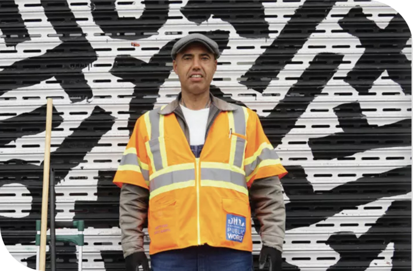 A PW worker standing in front of a mural