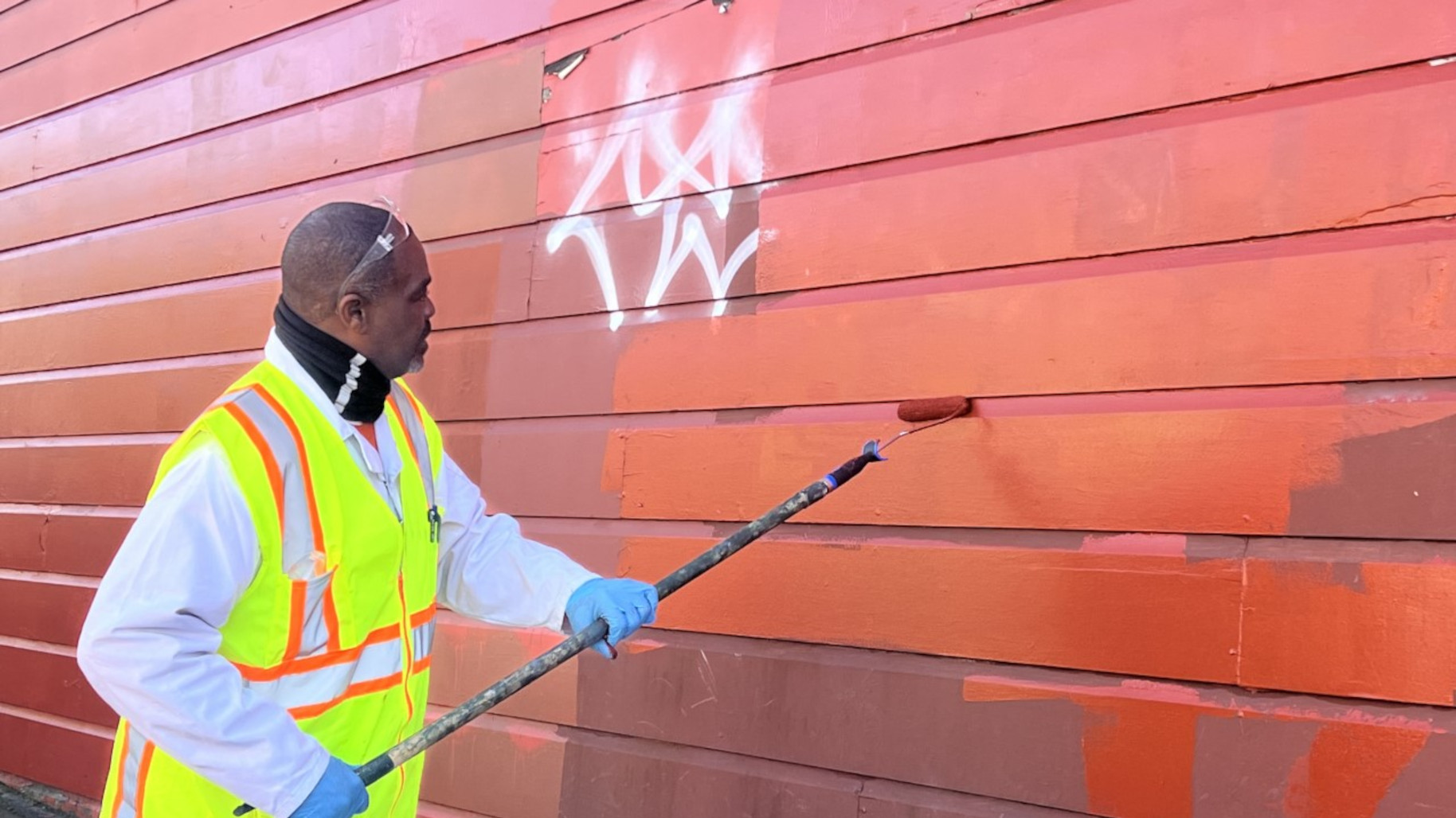 A person erasing a graphitti 