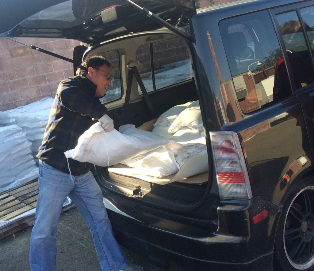 Man loading sandbags into his car