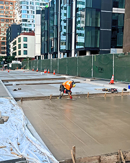 construction worker smoothing out wet concrete