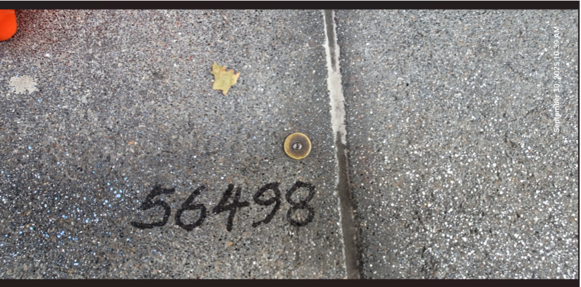 Example of a survey nail-and-tag monument in the sidewalk