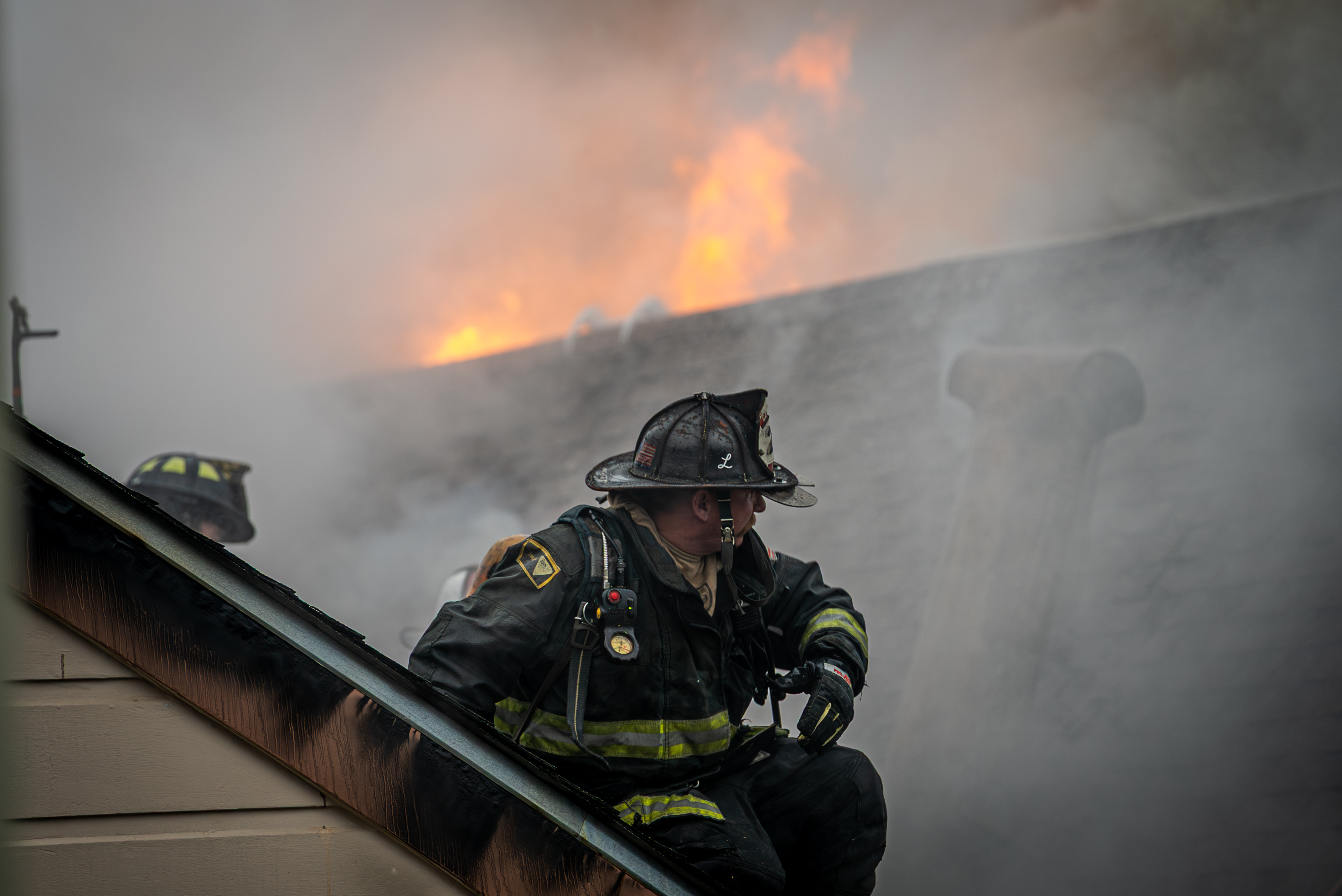 A firefighter on a burning roof