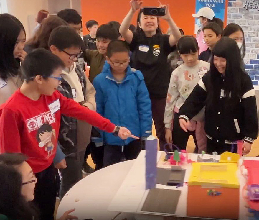 a boy testing a structure made out of art materials for Public Works Week