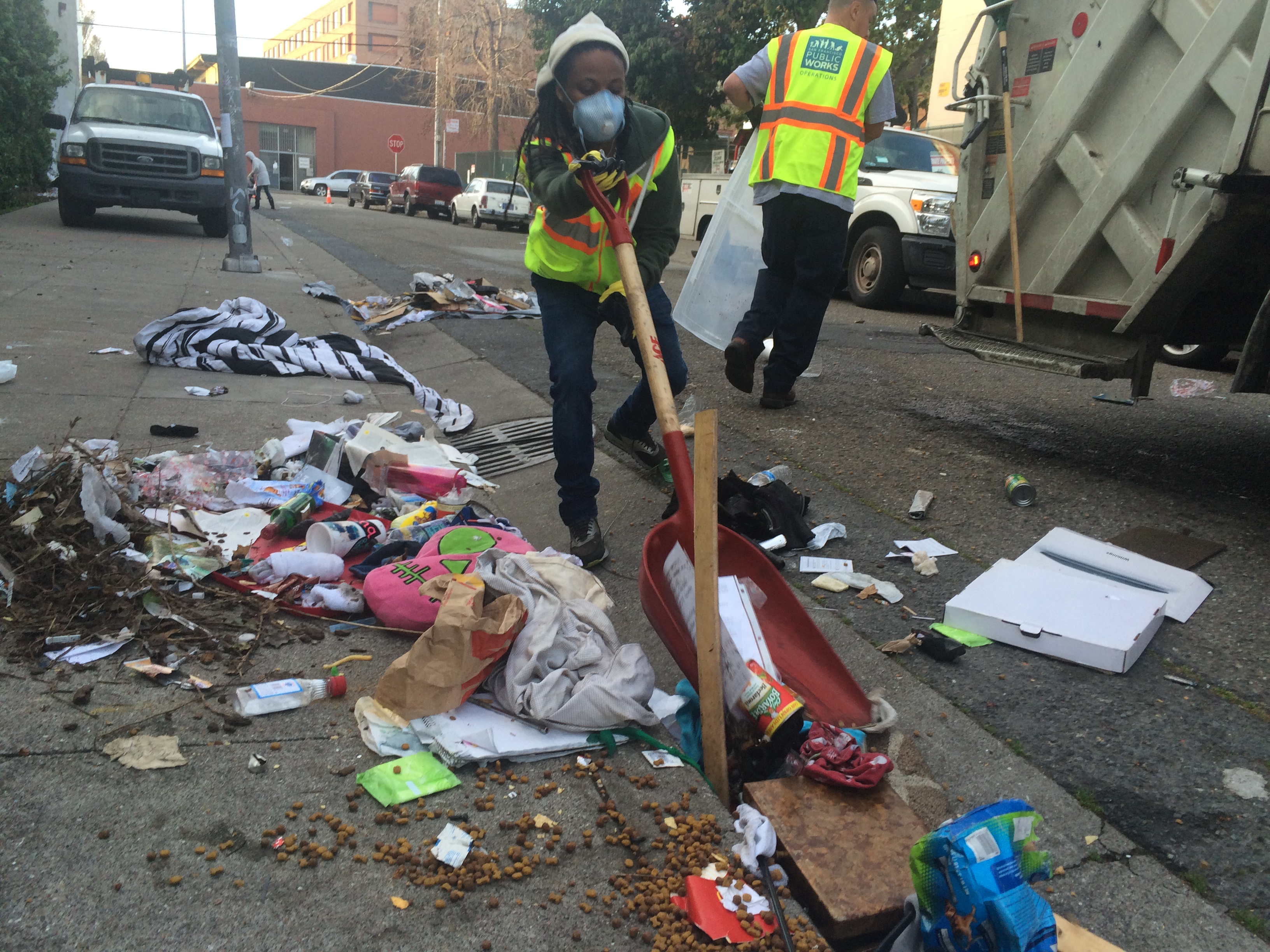 Worker cleaning litter-strewn street