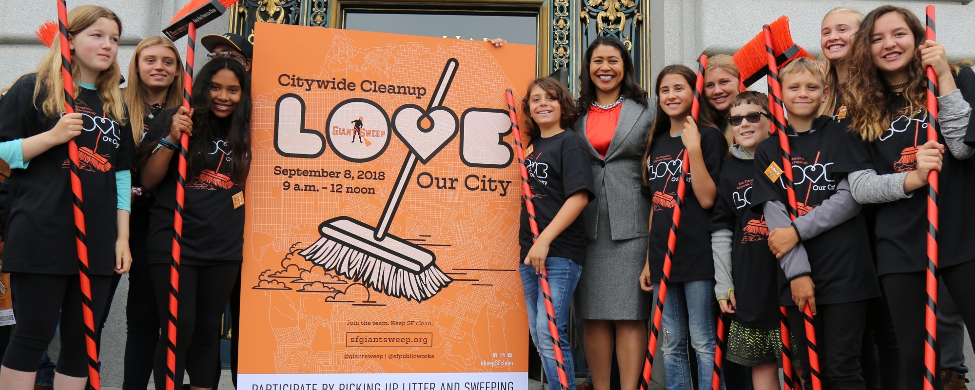Love Our City sign with mayor and students