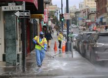clean corridors worker power washing the sidewalk