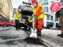A worker filling a pothole